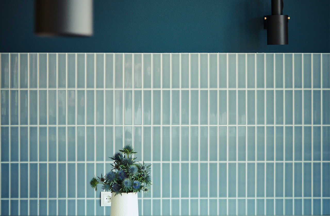 Flowers in front of blue tiles and a socket