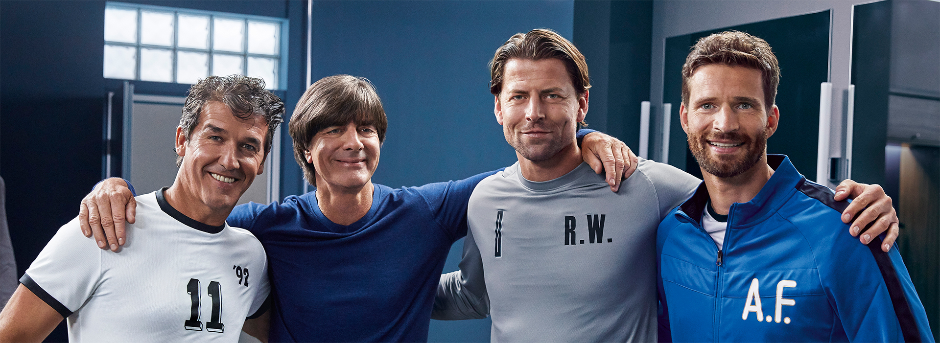 Jogi Löw umarmt sich mit Fussballern für Foto